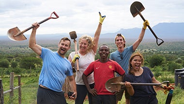 Global Angels volunteers posing with shovels after completing dig