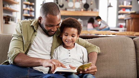 Father and young son reading together